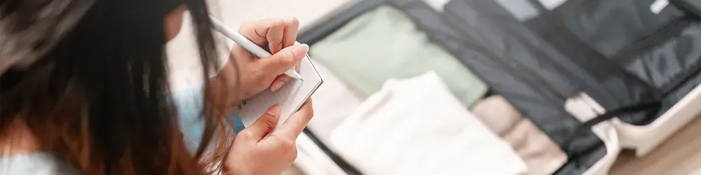 Woman using packing list to pack for her trip.